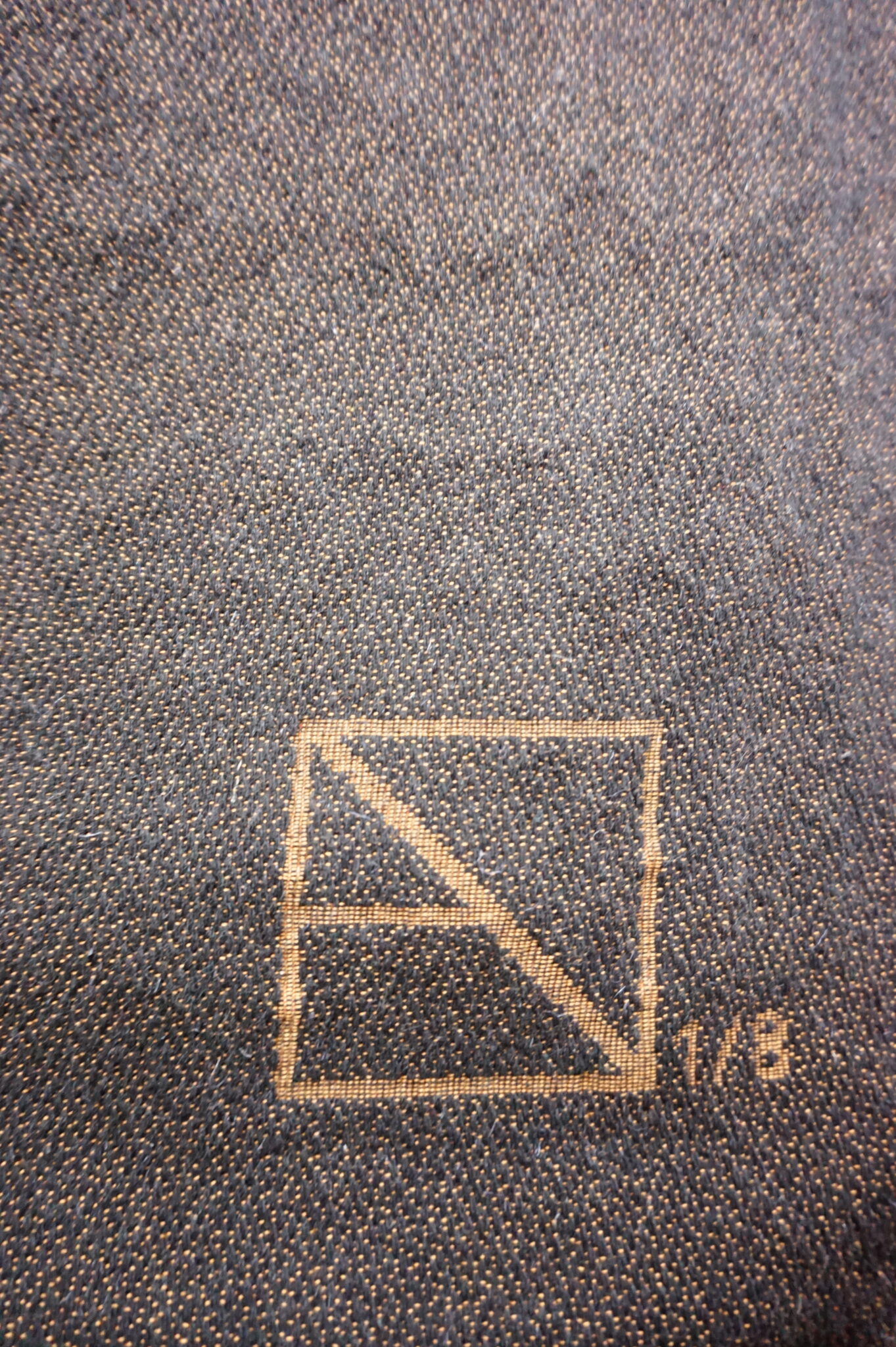 Signature de l'artiste et numérotation insérés dans le tissage